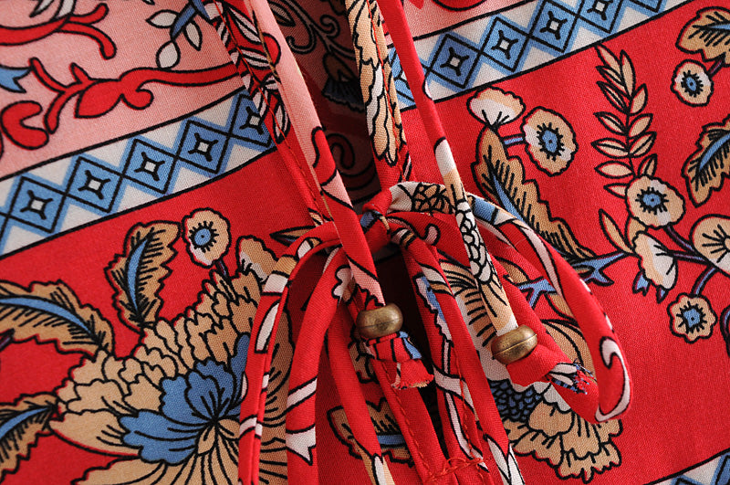 Close-up of red long sleeve floral dress for women featuring intricate blue and beige flower patterns with ties