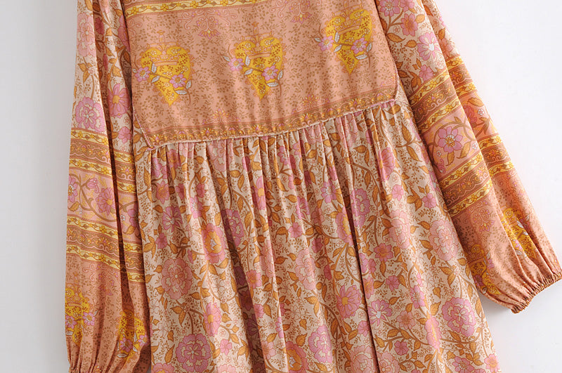 Close-up of Malbusaat long sleeve rayon tassel dress with floral patterns in pink and orange tones