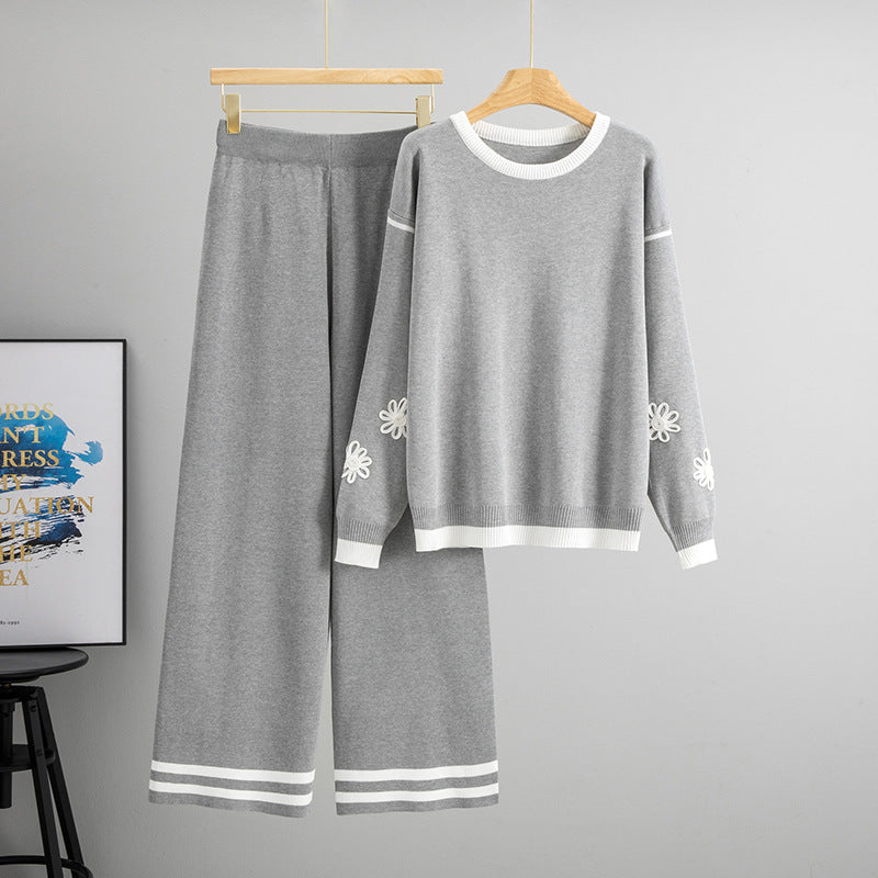 Stylish grey loose knit two piece set for women featuring floral designs on sleeves and wide-leg trousers