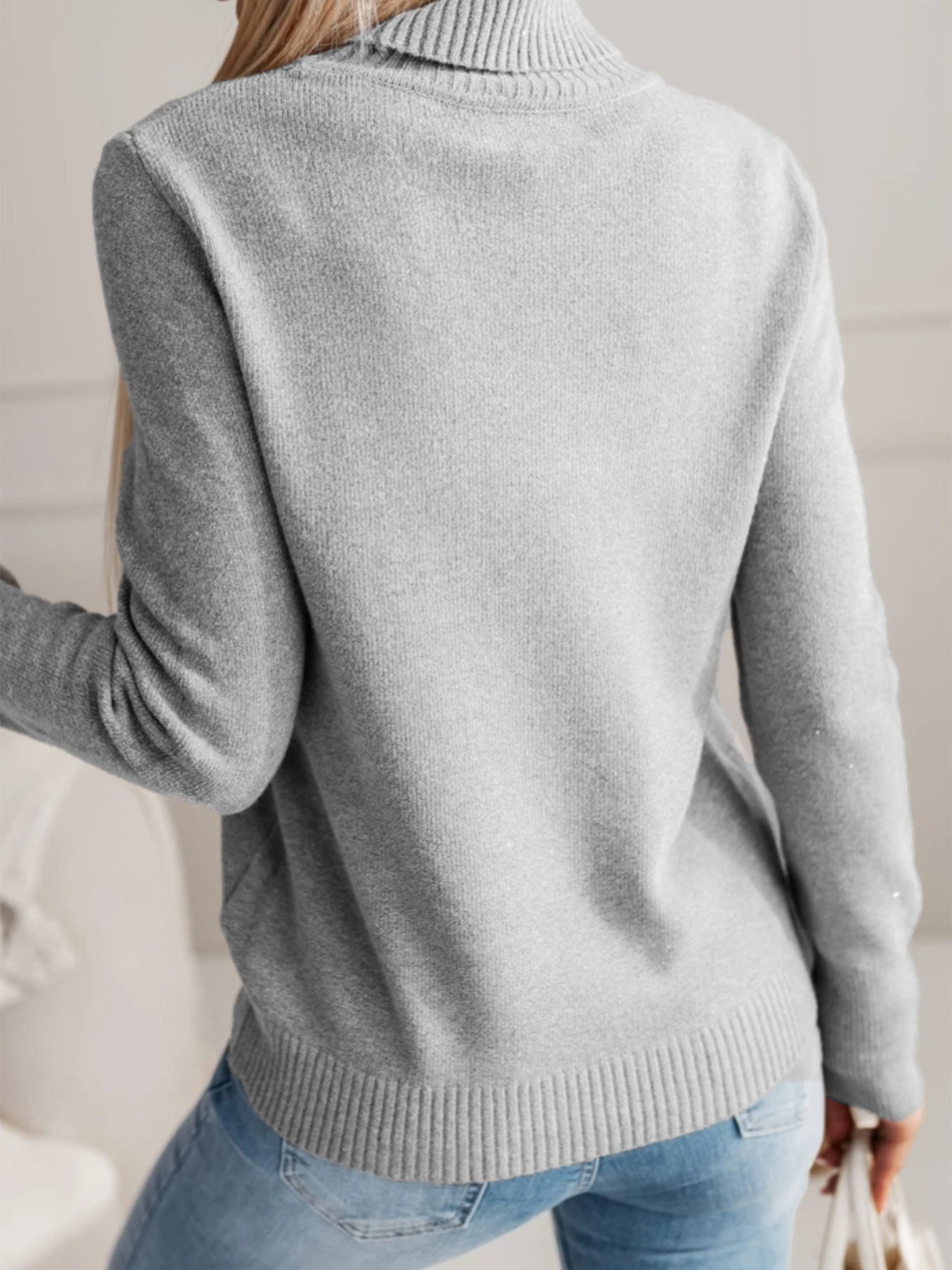 Back view of a grey women's knit lapel pullover top, featuring a relaxed fit and ribbed hem