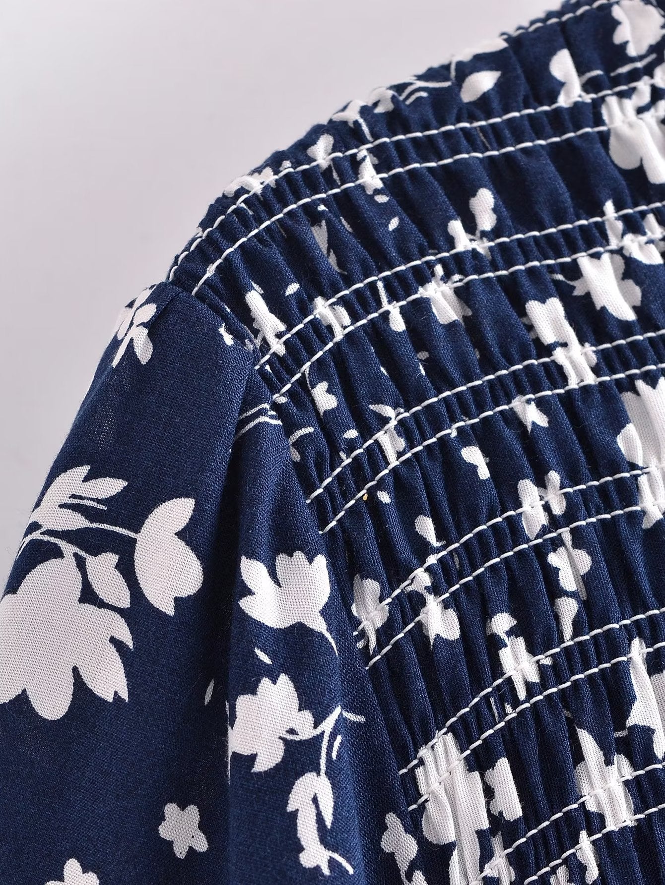 Close-up of Malbusaat women's summer floral dress showing navy fabric with white floral print and detailed stitching