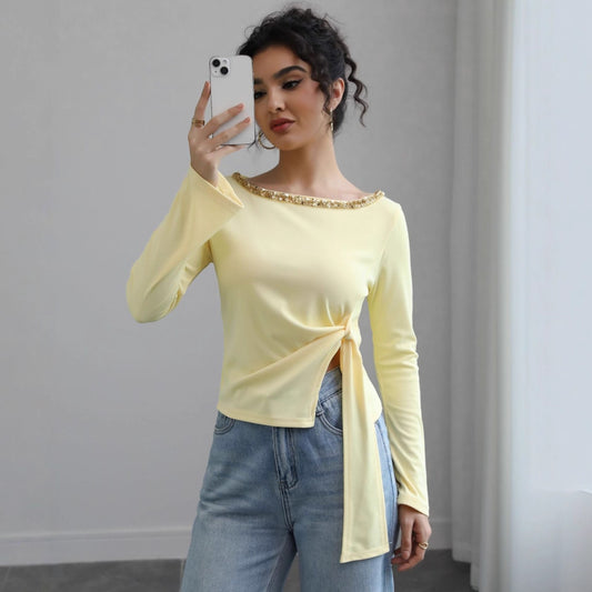 Malbusaat autumn lace up top in pale yellow with beaded neckline and side tie worn with blue jeans