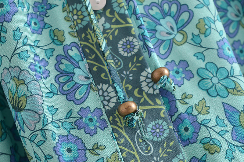 Close-up of Malbusaat bohemian summer maxi dress with blue floral print and wooden bead details