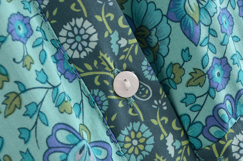 Close-up of floral patterned fabric and white button on Malbusaat bohemian summer maxi dress