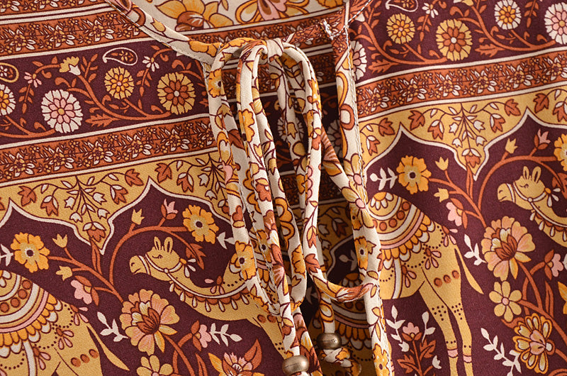 Close-up of Malbusaat boho floral dress online UK with detailed flower and giraffe print in warm tones