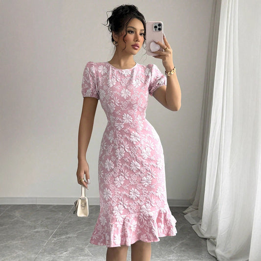 Woman wearing pink floral fishtail bodycon dress with puff sleeves taking a mirror selfie indoors