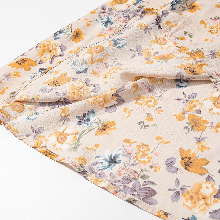 Close-up of lace up floral pullover dress with a vibrant flower pattern in soft hues