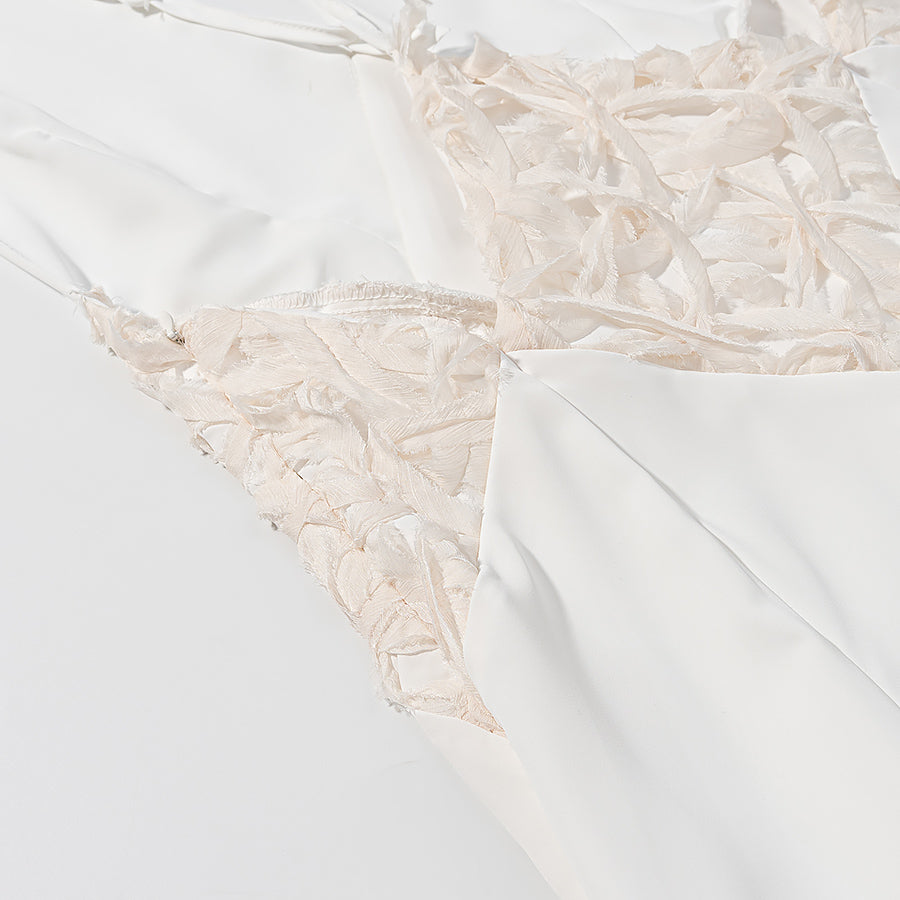 Close-up of elegant lace maxi dress by Malbusaat showing detailed lace fabric and smooth white material