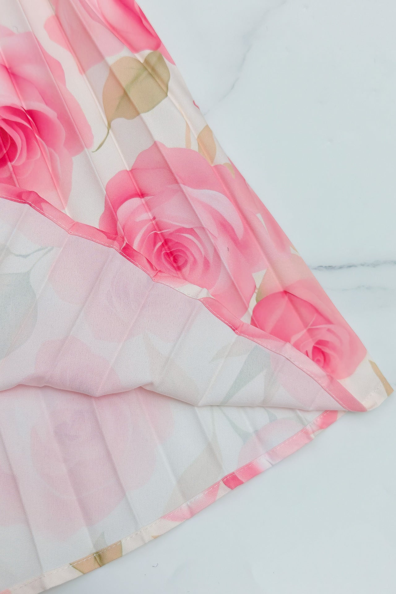 Malbusaat printed pleated maxi dress featuring a floral design with pink roses on a lightweight fabric