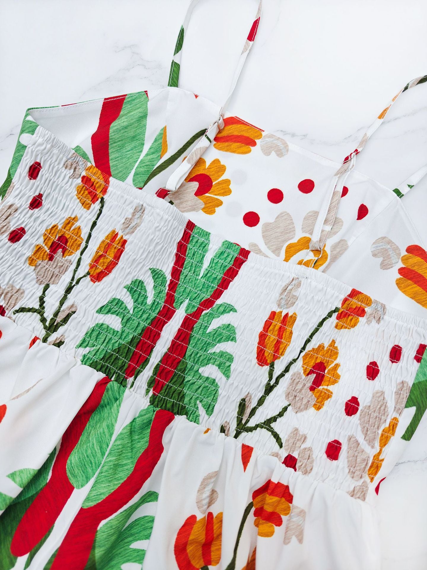 Malbusaat printed strap tiered dress featuring vibrant floral patterns and smocked bodice detail