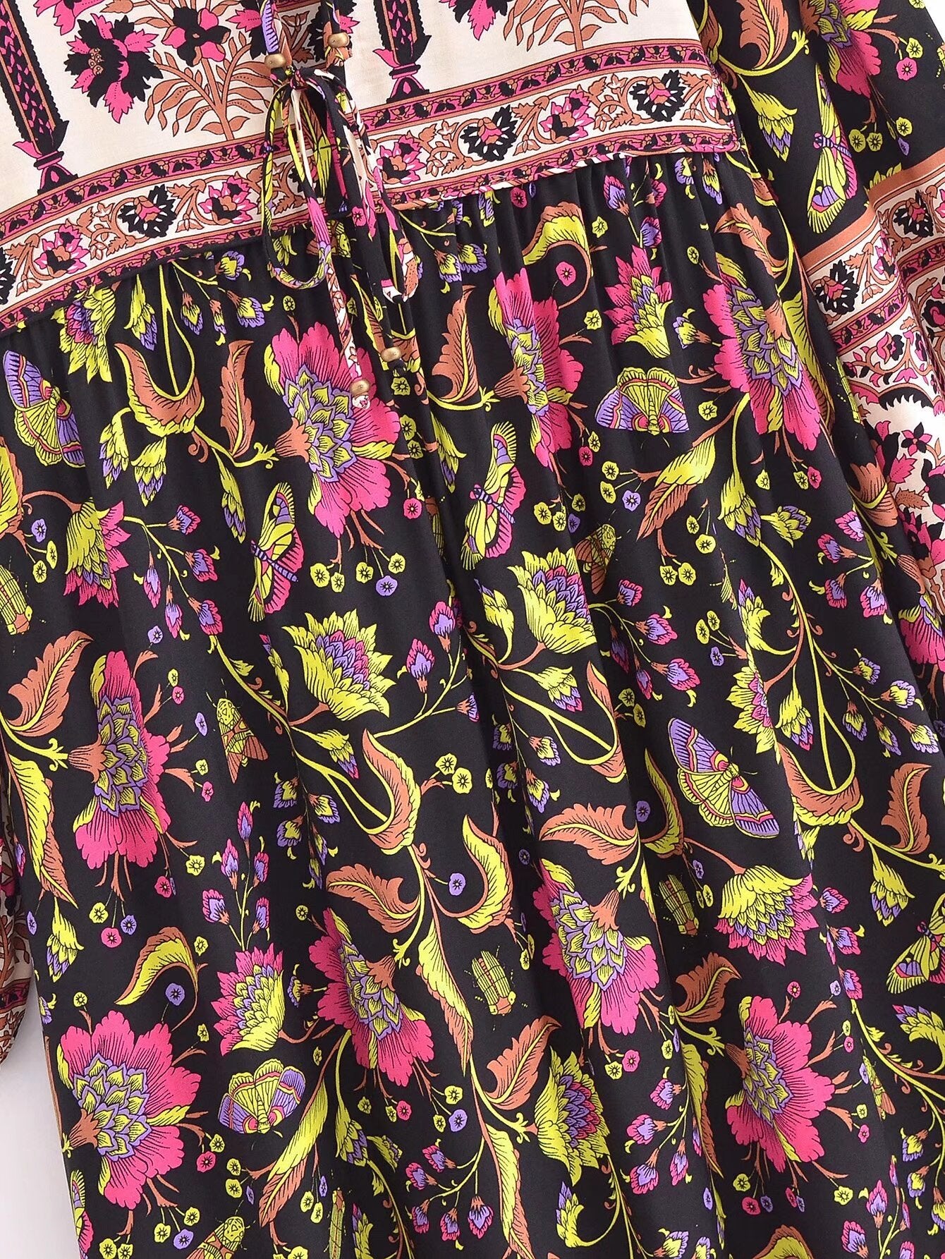 Close-up of Malbusaat spring floral print maxi dress featuring vibrant pink and yellow flowers on black fabric