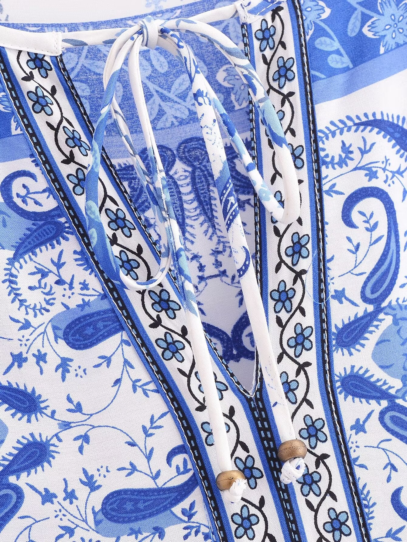 Close-up of blue and white patterned elegant puff sleeve spring midi dress neck with tie detail by Malbusaat