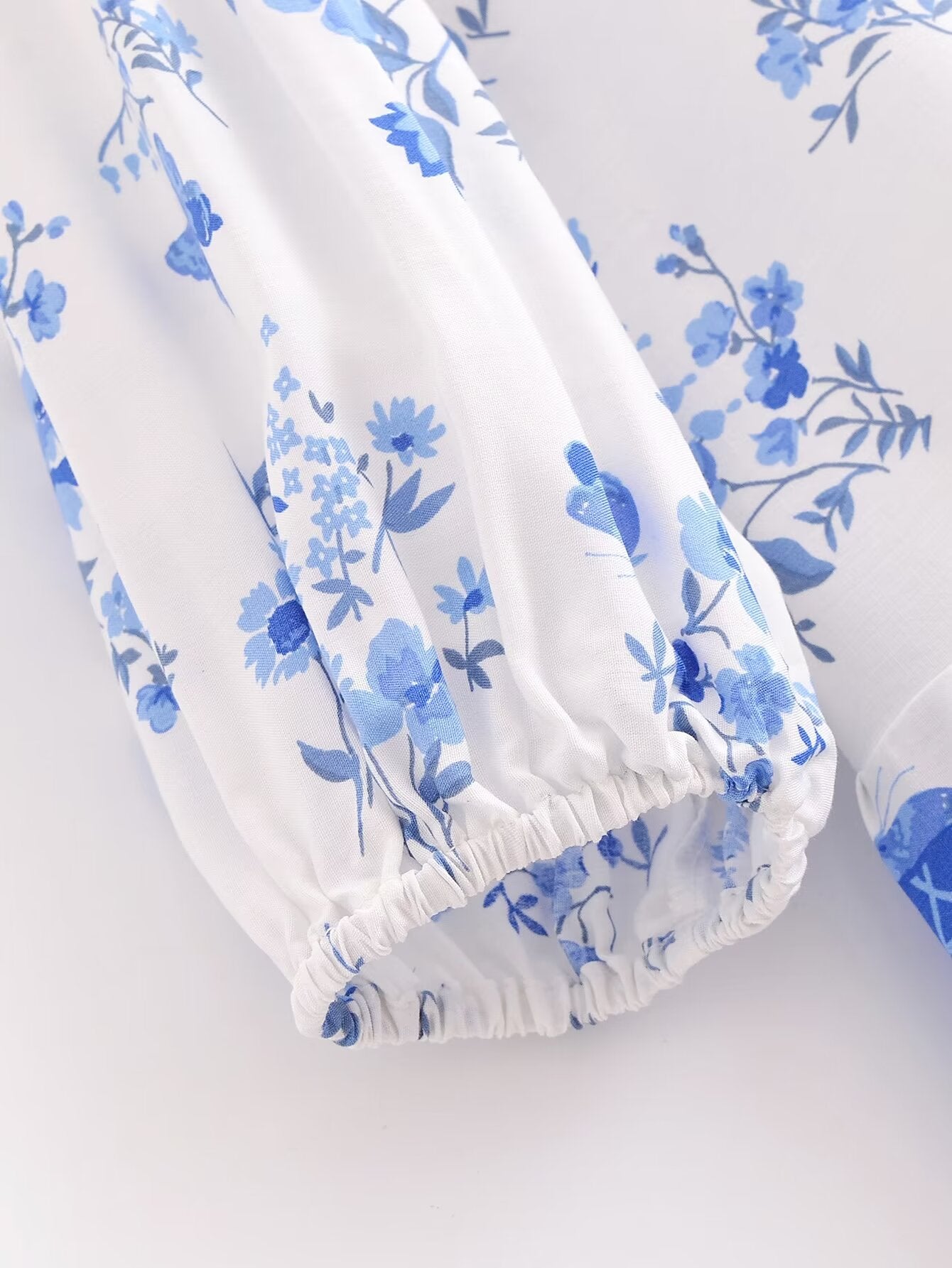 Close-up of blue floral pattern and elastic cuff on elegant puff sleeve spring midi dress by Malbusaat