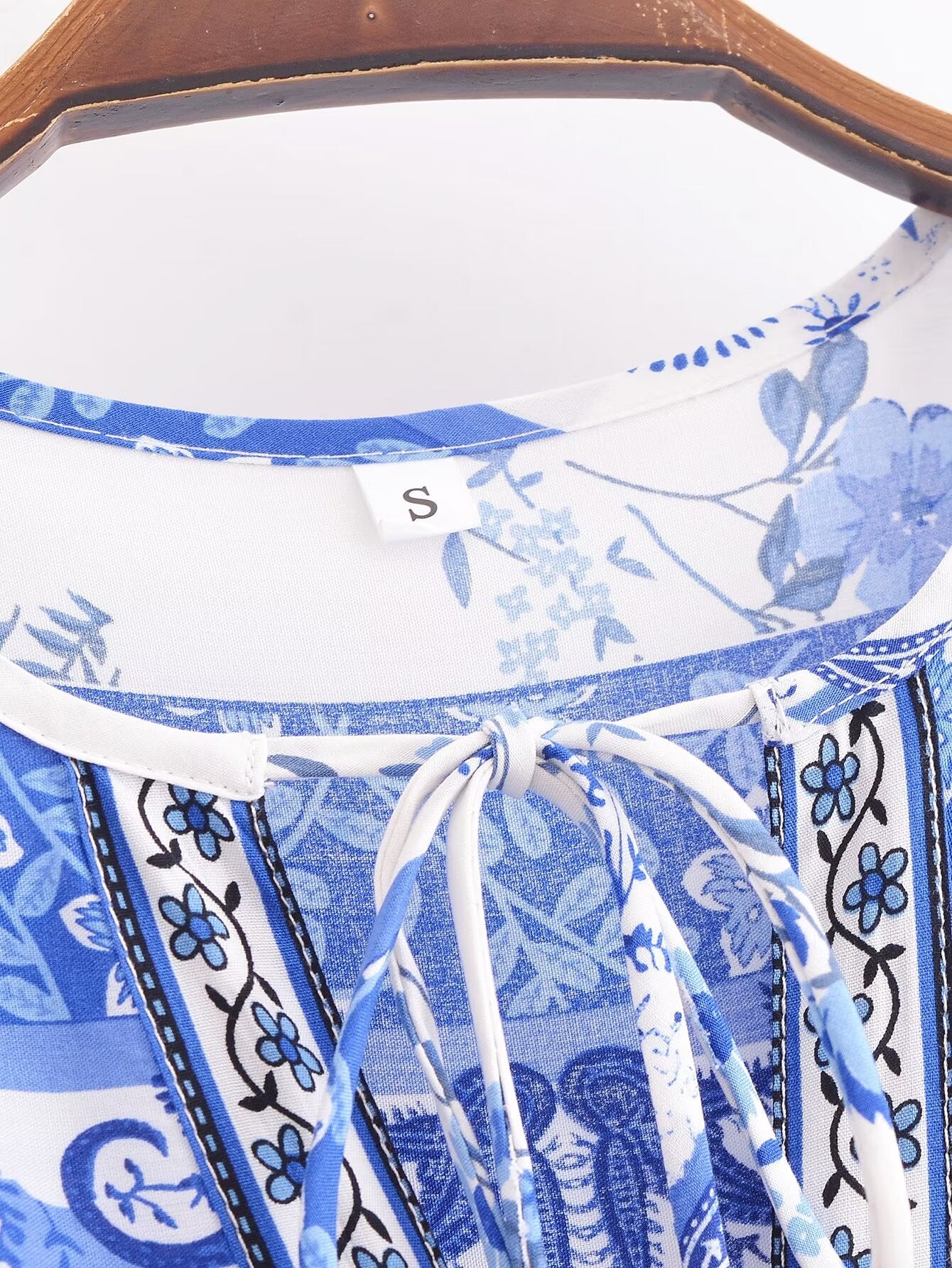 Malbusaat elegant puff sleeve spring midi dress in blue and white floral print hanging on wooden hanger