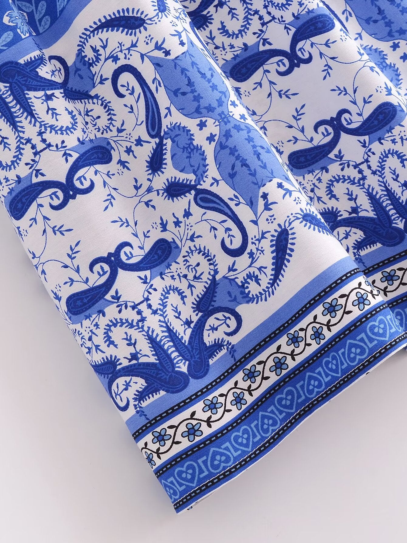 Close-up of blue and white fabric detail on elegant puff sleeve spring midi dress by Malbusaat