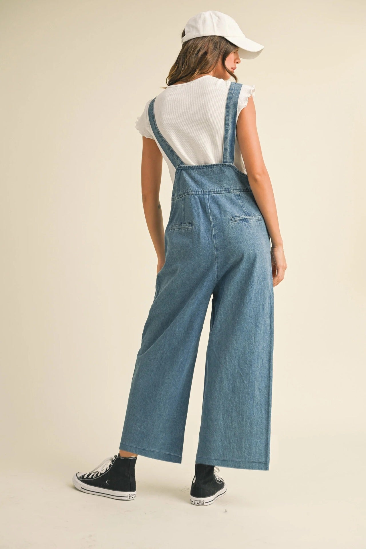 Back view of women's denim suspender pants from Malbusaat with wide-leg design and casual style